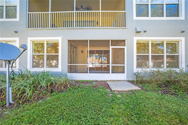 back of property with a balcony and a yard