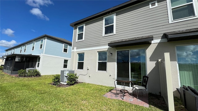 rear view of property featuring a patio, a yard, and central air condition unit