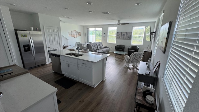 kitchen with white cabinets, sink, a kitchen island with sink, dark wood-type flooring, and appliances with stainless steel finishes