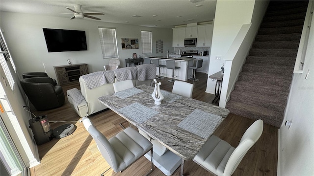 dining space with ceiling fan and hardwood / wood-style flooring