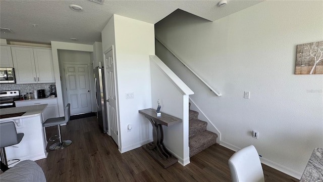 staircase featuring a textured ceiling and hardwood / wood-style flooring