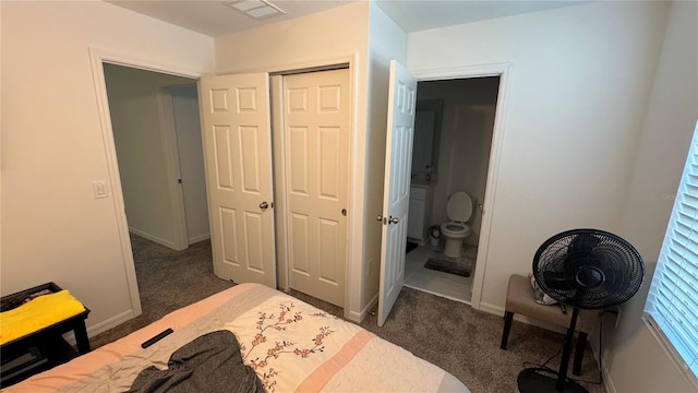 carpeted bedroom with a closet and ensuite bath