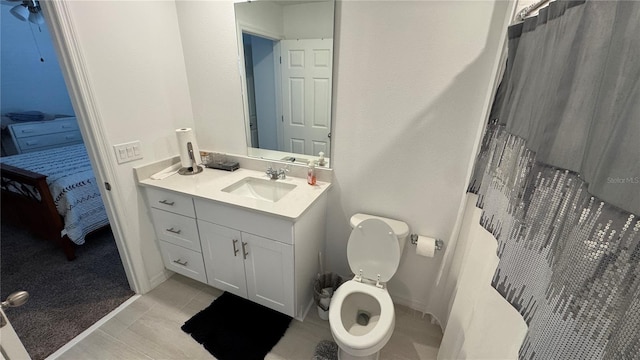 bathroom with curtained shower, vanity, and toilet