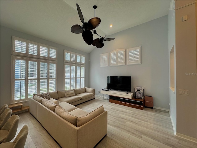 living room featuring ceiling fan, light wood-type flooring, and a healthy amount of sunlight