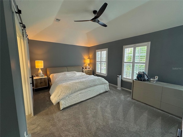 bedroom featuring lofted ceiling, ceiling fan, carpet flooring, and a barn door