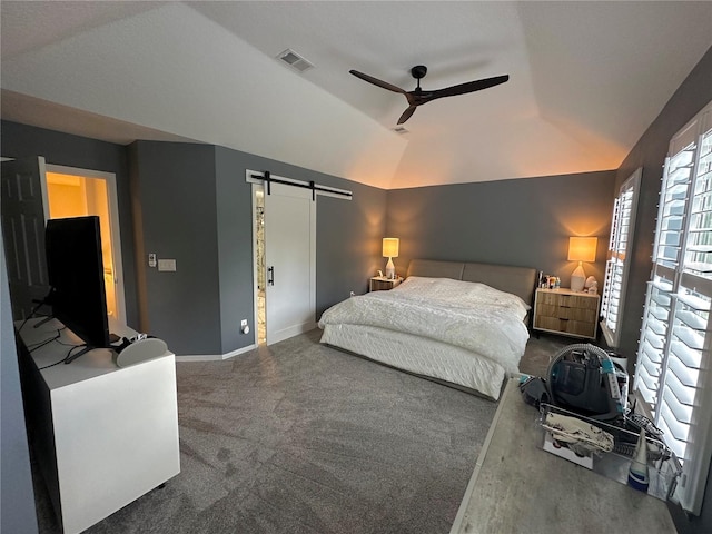 bedroom featuring lofted ceiling, ceiling fan, carpet floors, and a barn door