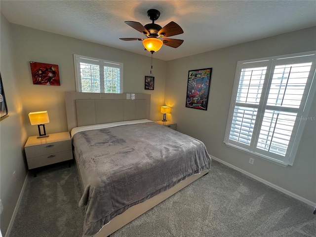 bedroom featuring multiple windows, dark colored carpet, and ceiling fan