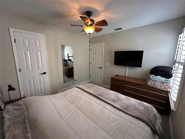 bedroom with a textured ceiling and ceiling fan