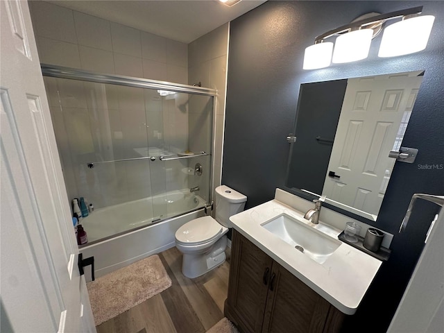 full bathroom featuring enclosed tub / shower combo, vanity, toilet, and hardwood / wood-style flooring