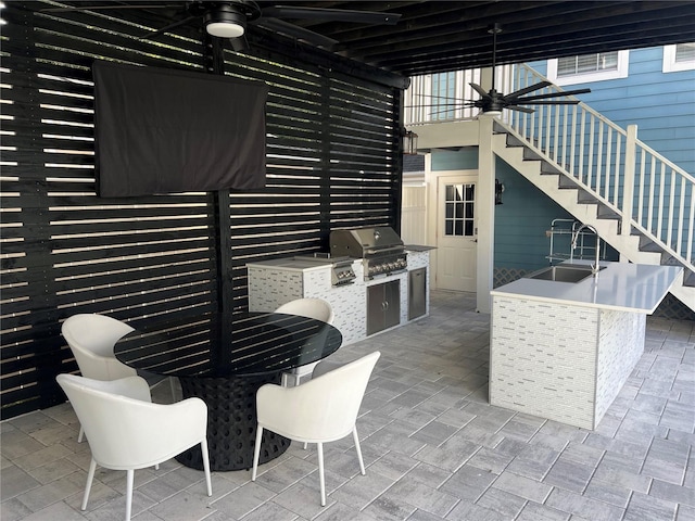 view of patio / terrace with area for grilling, ceiling fan, a grill, and sink