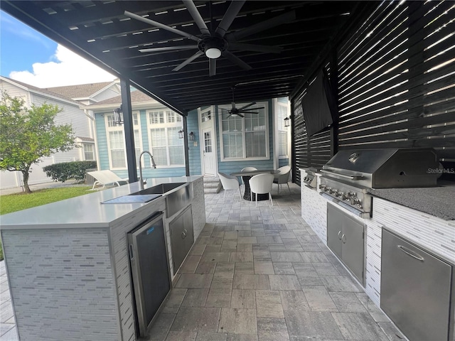 view of patio with a grill, ceiling fan, and exterior kitchen