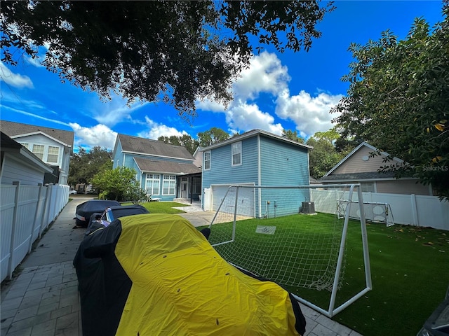 rear view of property featuring a yard and a garage