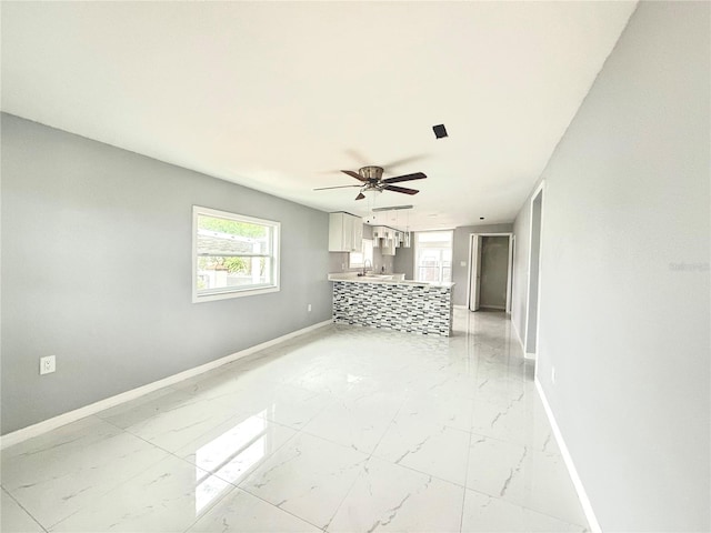 unfurnished living room featuring sink and ceiling fan