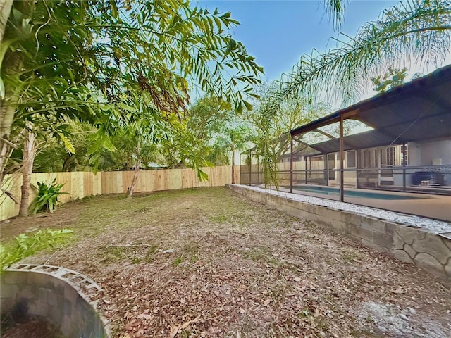 view of yard with a fenced in pool and a lanai