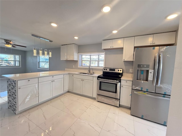 kitchen with appliances with stainless steel finishes, kitchen peninsula, sink, and white cabinets