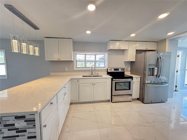 kitchen featuring sink, white cabinetry, appliances with stainless steel finishes, kitchen peninsula, and pendant lighting