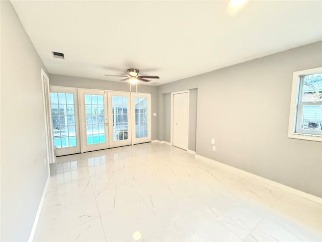 spare room featuring ceiling fan and french doors