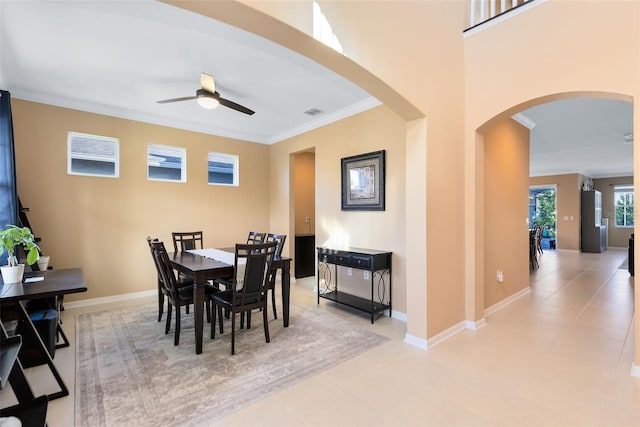 dining space featuring ceiling fan, crown molding, and light tile patterned floors