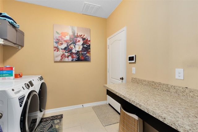 clothes washing area featuring light tile patterned flooring, cabinets, and separate washer and dryer