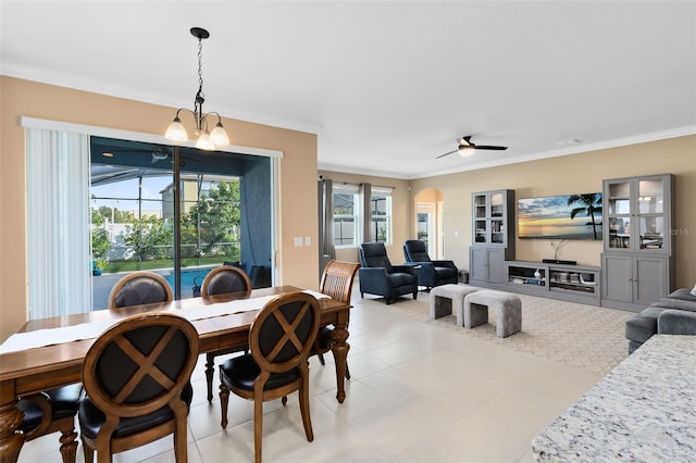 tiled dining space featuring ceiling fan with notable chandelier and crown molding