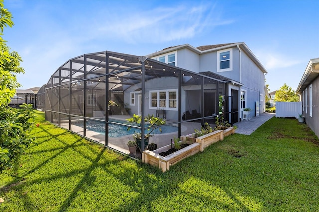 back of property featuring a lanai, a patio area, a yard, and a fenced in pool