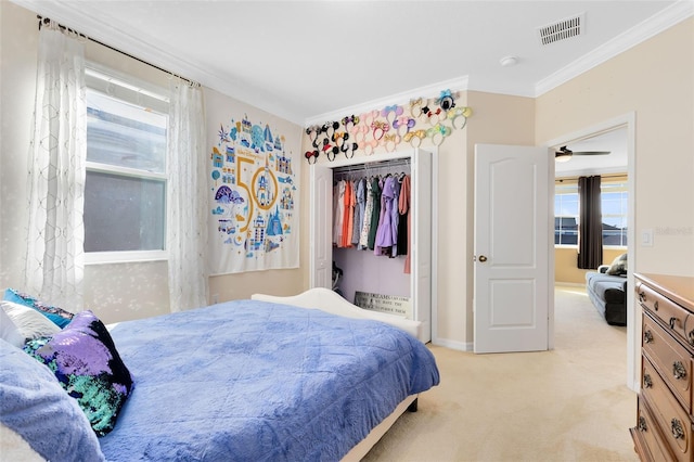 carpeted bedroom with crown molding and a closet