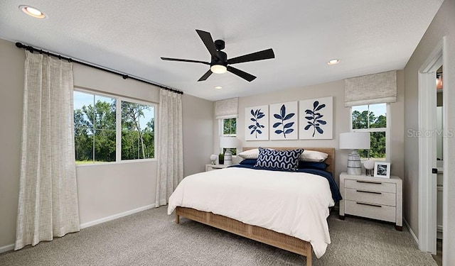 carpeted bedroom with a textured ceiling and ceiling fan