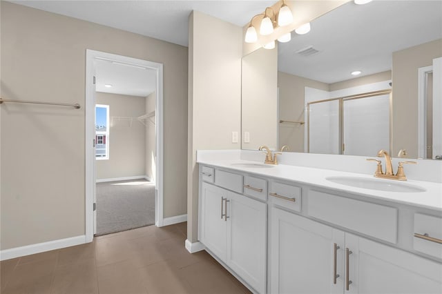 bathroom with tile patterned floors, vanity, and a shower with shower door