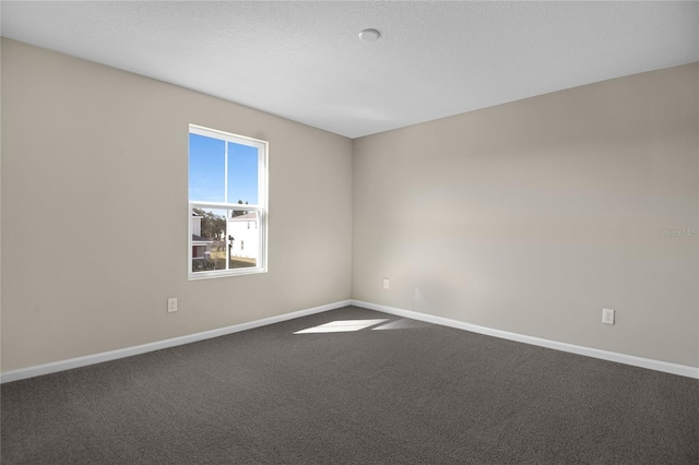 carpeted empty room featuring a textured ceiling