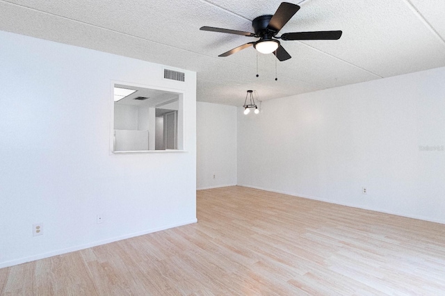 spare room featuring ceiling fan and light hardwood / wood-style flooring