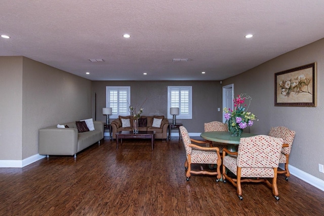 dining area featuring a textured ceiling and dark hardwood / wood-style floors