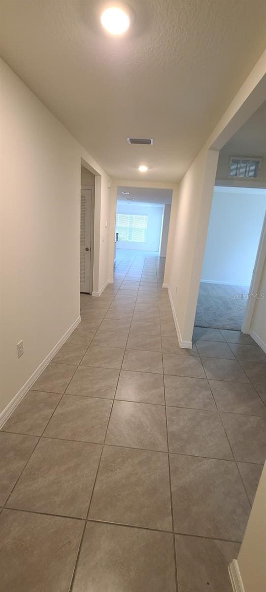 hall with light tile patterned floors