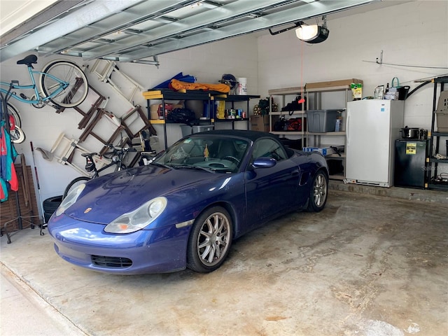 garage with white fridge and a garage door opener