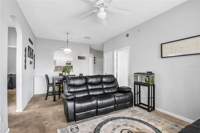 carpeted living room with ceiling fan