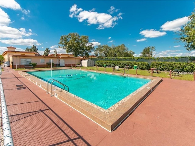 view of swimming pool with a yard and a patio