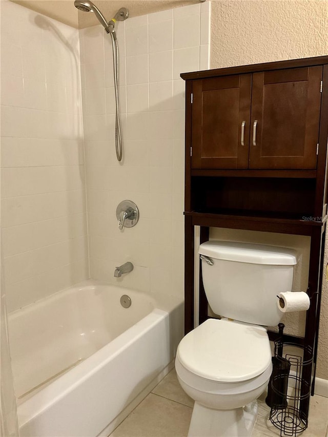 bathroom featuring tile patterned floors, washtub / shower combination, and toilet