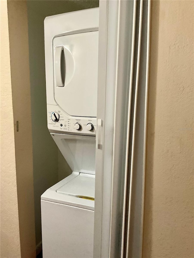 clothes washing area featuring stacked washing maching and dryer