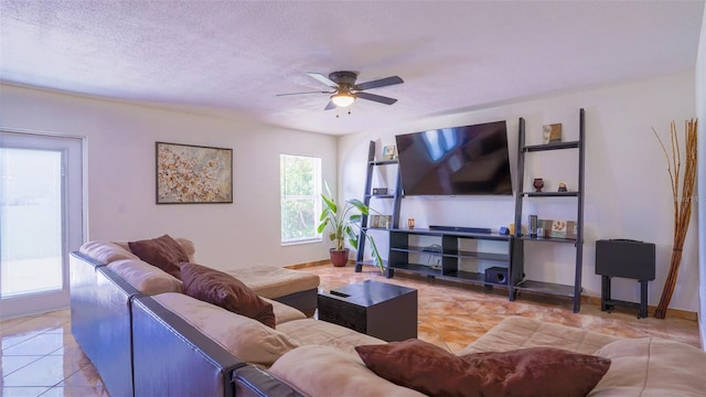 living room with a textured ceiling, light tile patterned floors, and ceiling fan