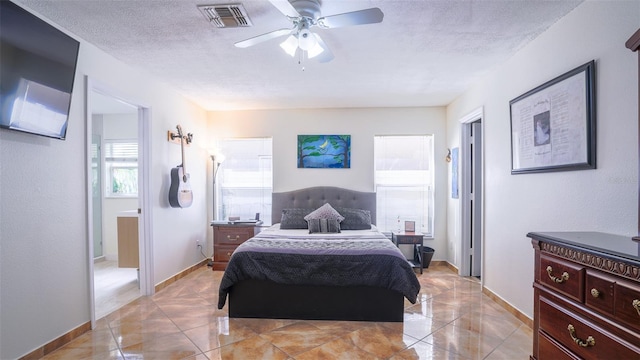 bedroom with ceiling fan and a textured ceiling