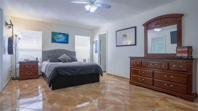 tiled bedroom featuring ceiling fan and a textured ceiling