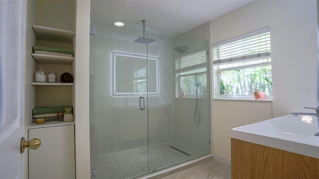 bathroom with a shower with door and vanity