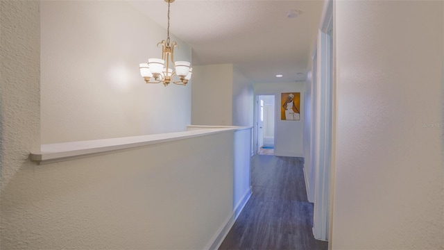 hall featuring an inviting chandelier and dark hardwood / wood-style floors