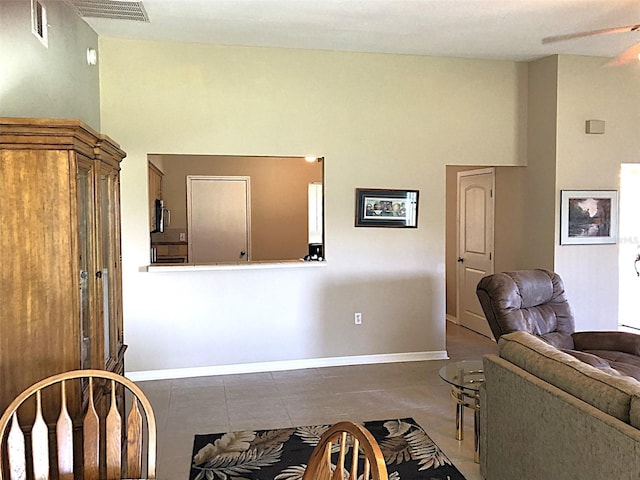 living room with ceiling fan and dark tile patterned flooring