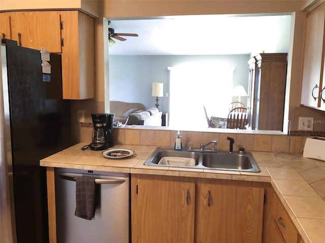 kitchen with tile countertops, stainless steel dishwasher, sink, and ceiling fan