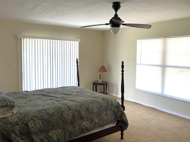 carpeted bedroom featuring a textured ceiling and ceiling fan