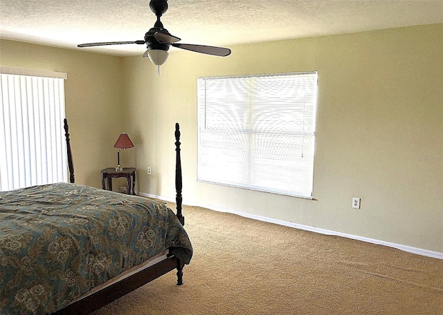 bedroom with a textured ceiling, carpet flooring, and ceiling fan