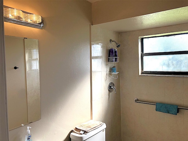 bathroom with toilet and tiled shower