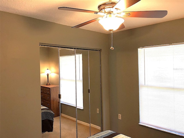 carpeted bedroom featuring a closet, ceiling fan, and a textured ceiling