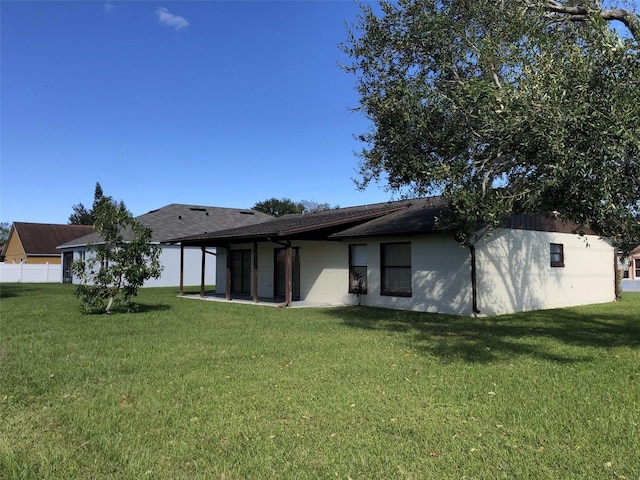 rear view of property featuring a yard