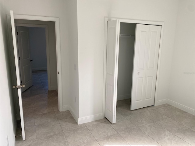 unfurnished bedroom with a closet and light tile patterned floors